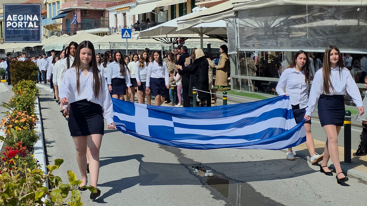 Η μεγάλη μαθητική παρέλαση στην παραλία της Αίγινας, για τον εορτασμό της 25ης Μαρτίου 1821.